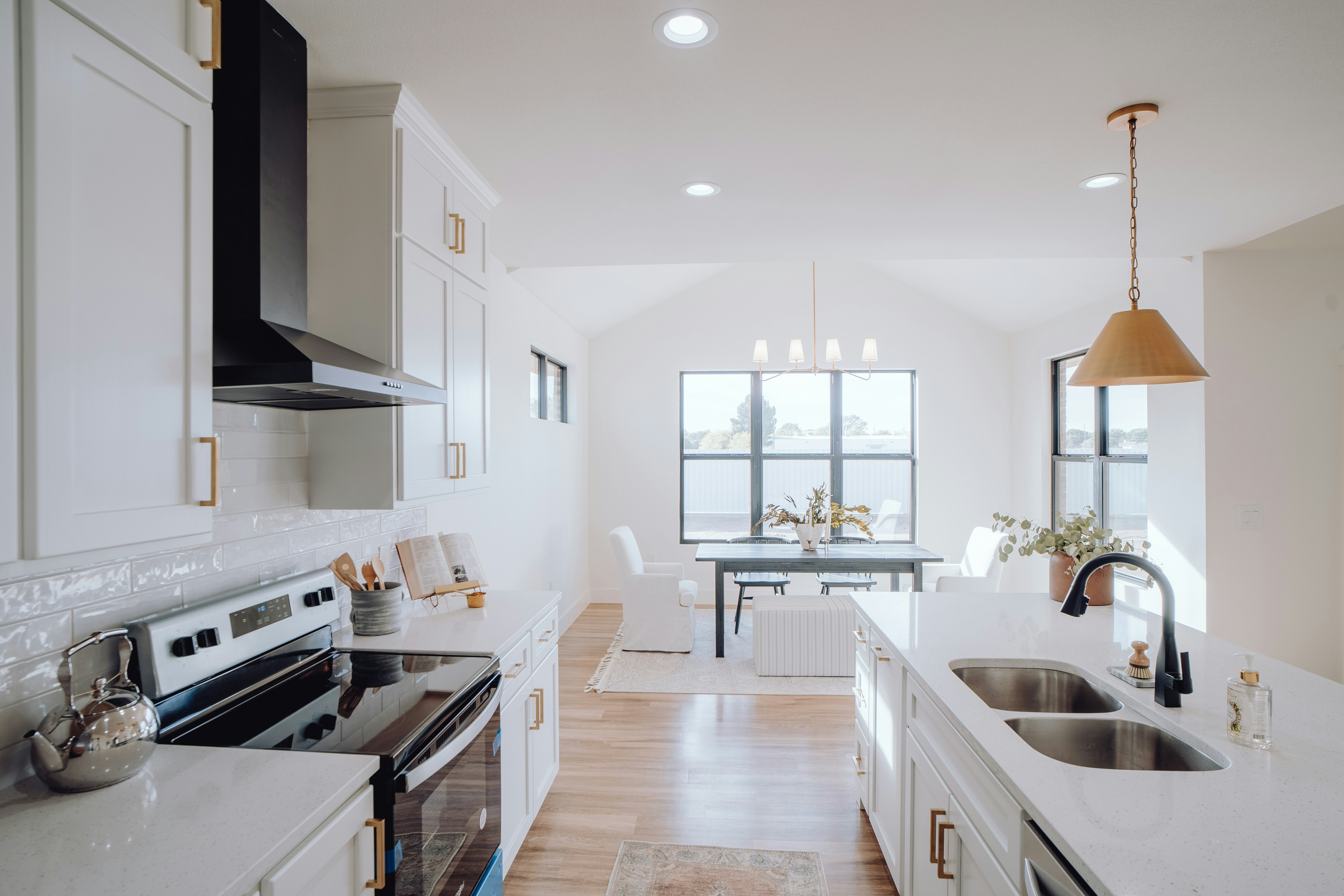 Bright modern kitchen with white cabinetry and gold hardware